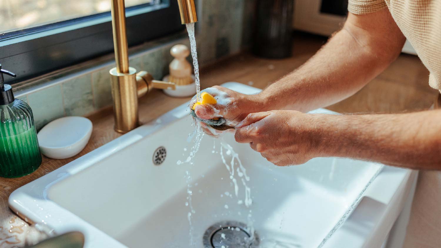 A man washing utensils in the sink