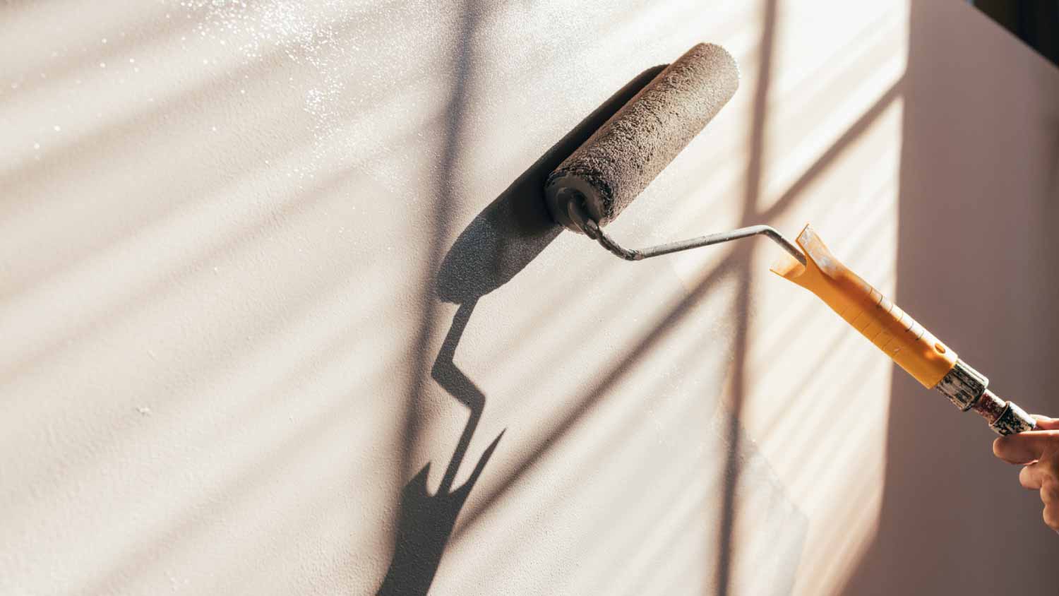 Woman painting panel with paint roller
