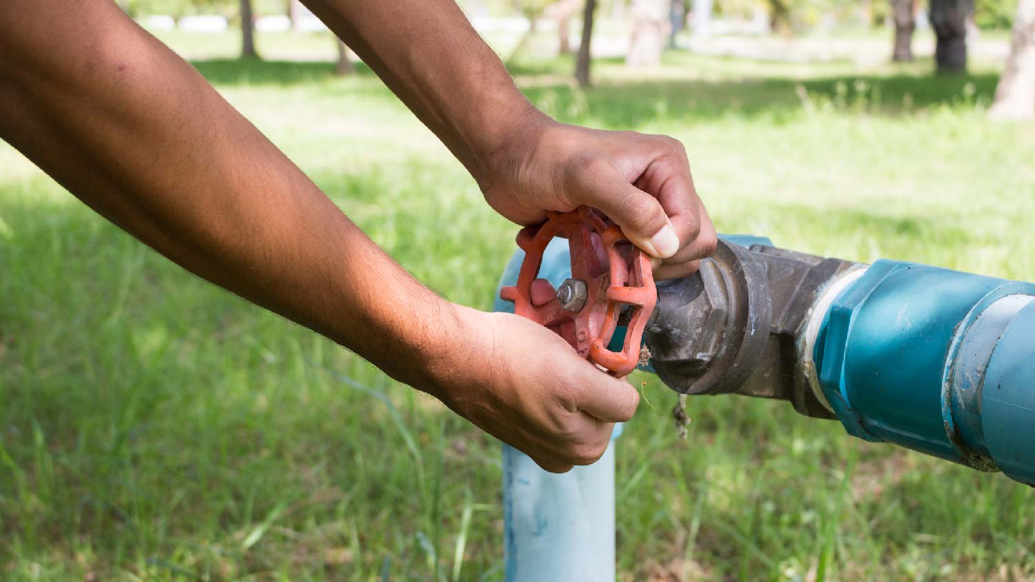 A man turning on the water valve