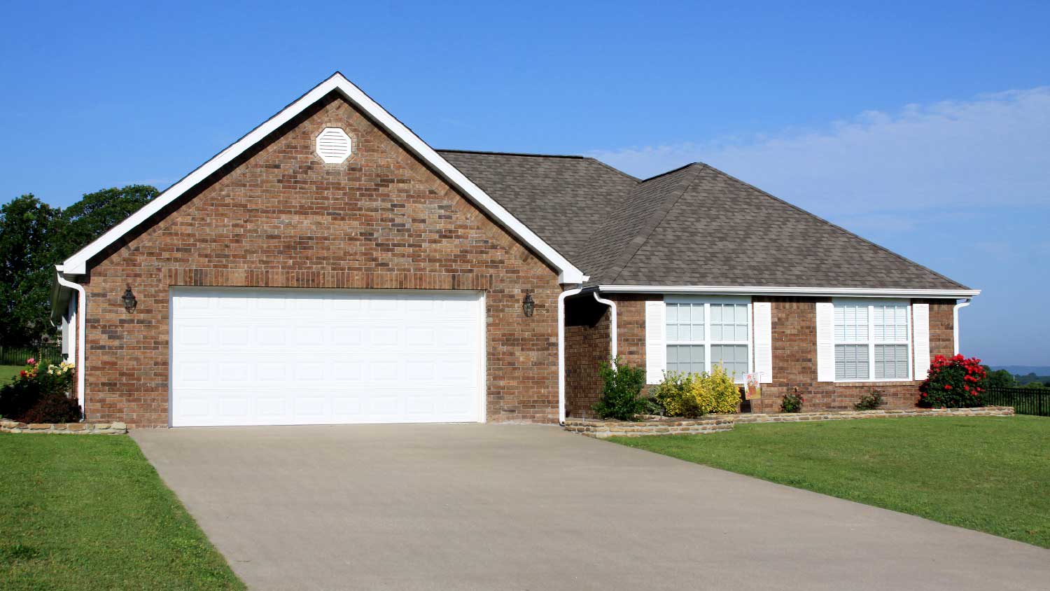 A brick house with a concrete driveway