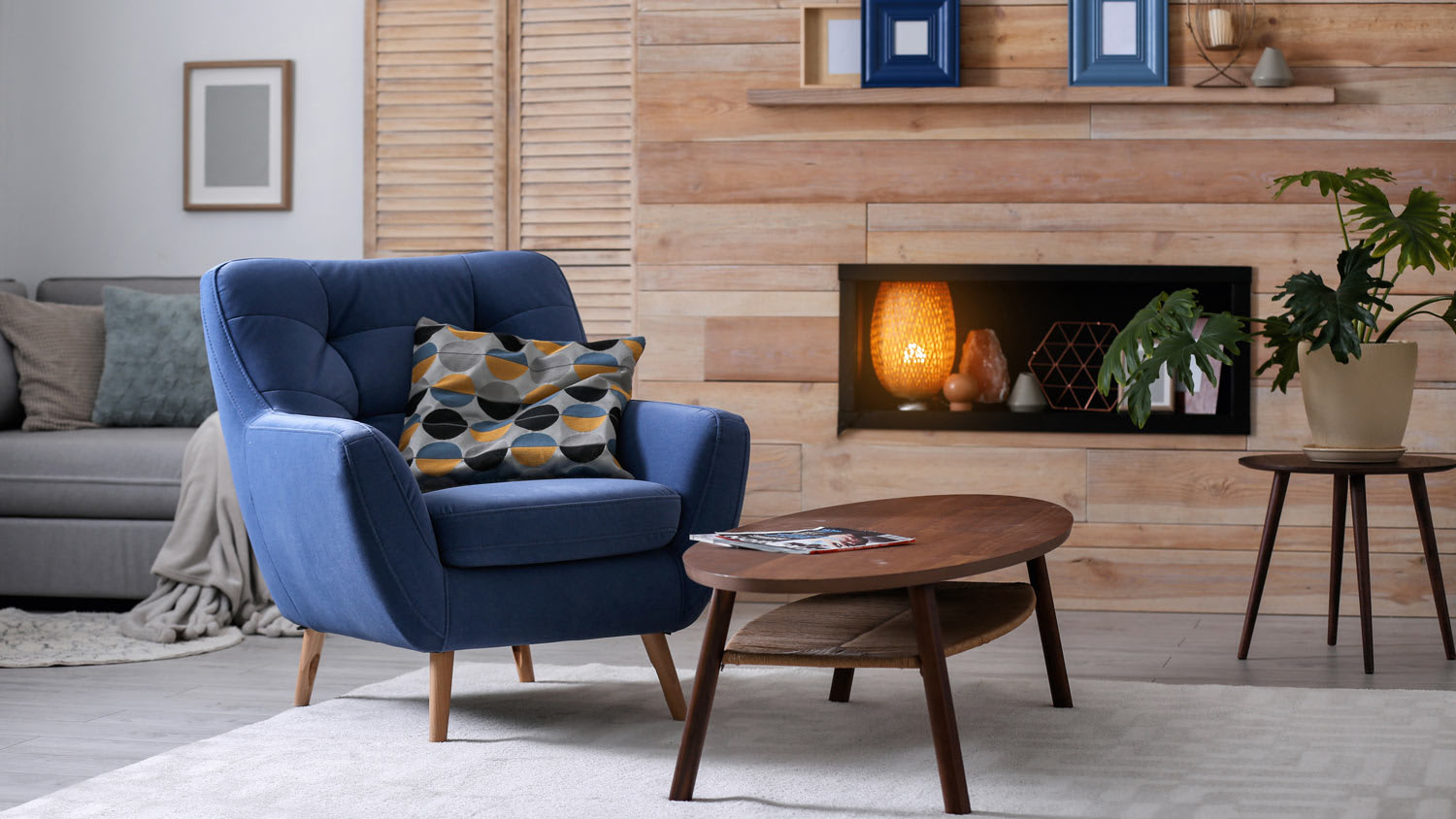 A living room with a wood plank wall and a fireplace
