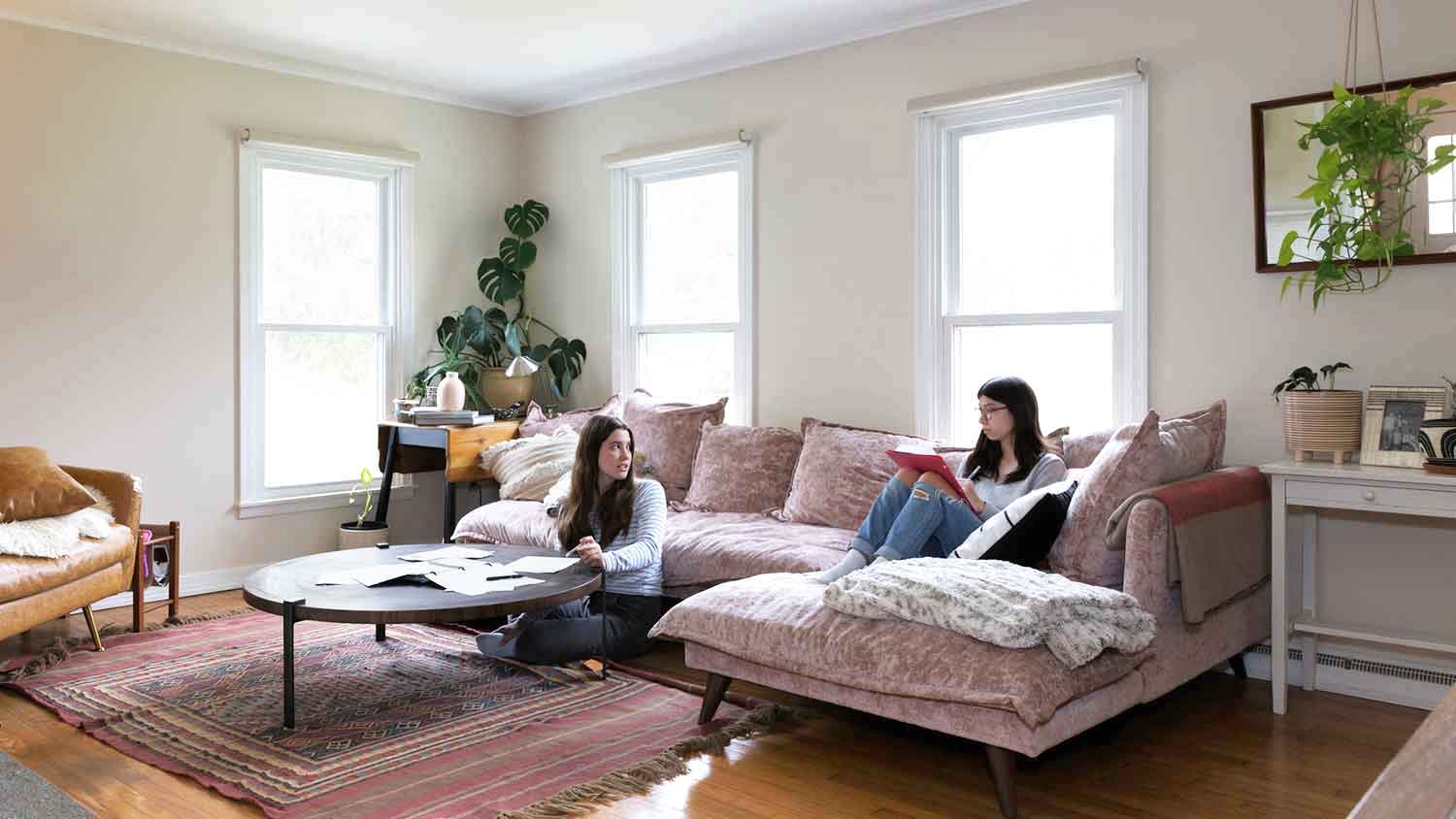 Teen girls doing homework in the living room