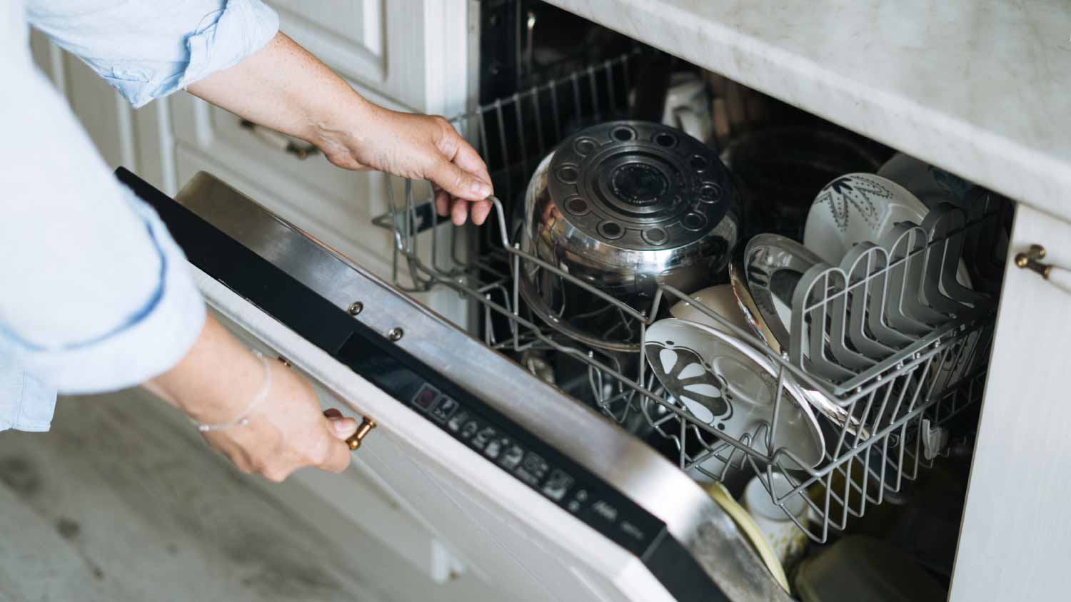 A person opening a dishwasher