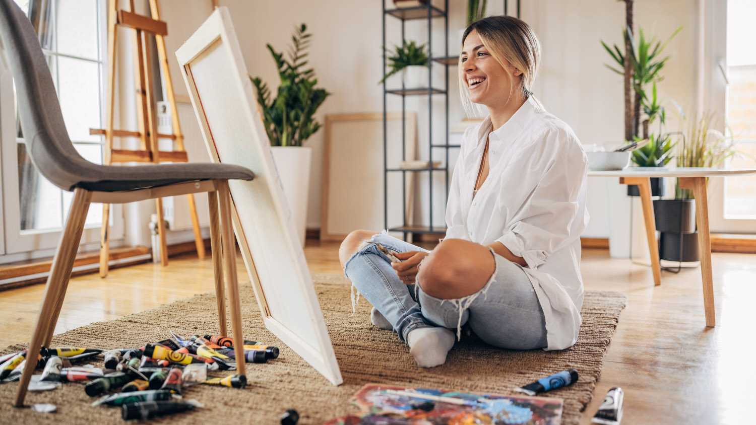 A woman painting with a brush her living room