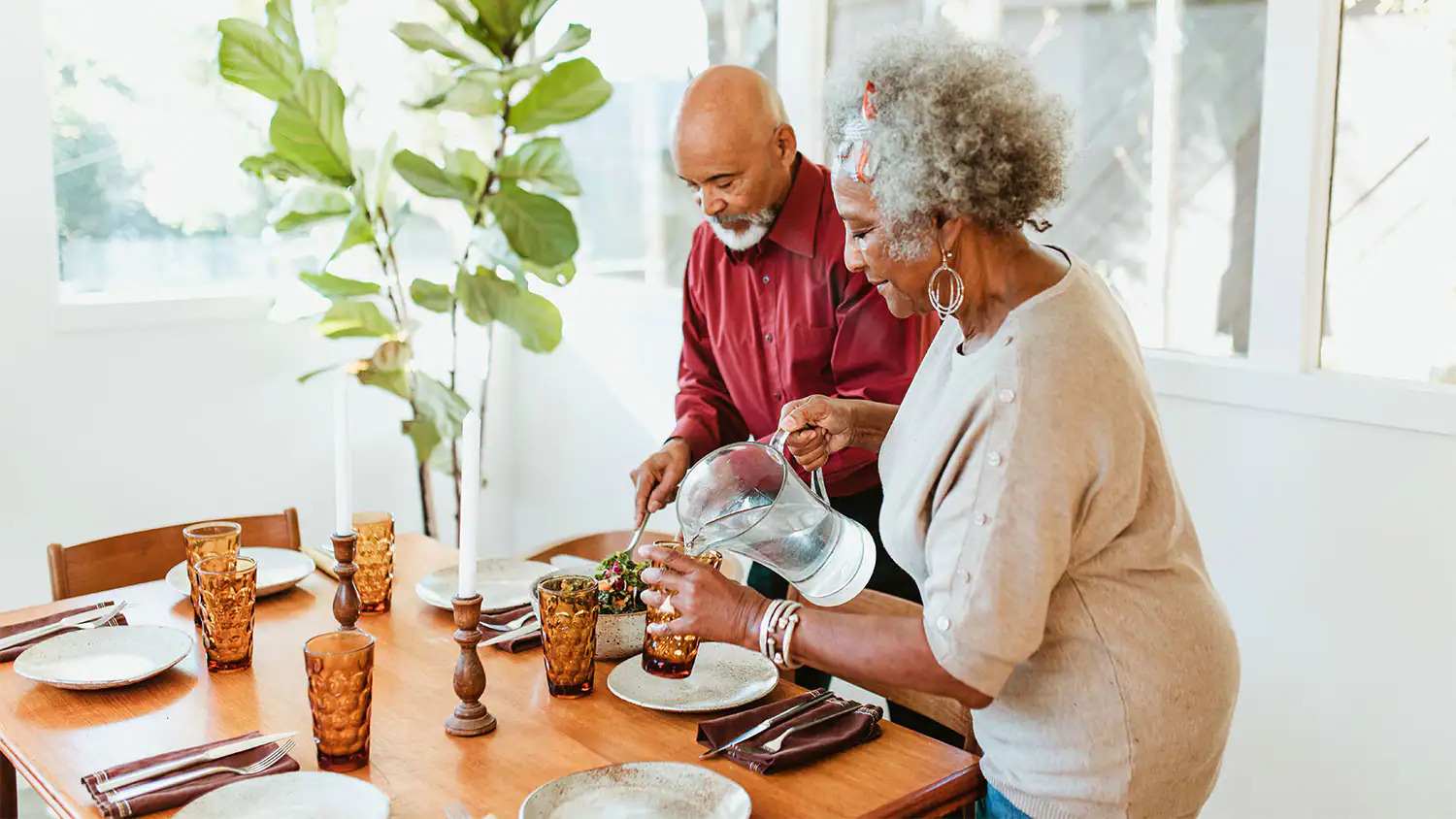 Couple pouring water from pitcher