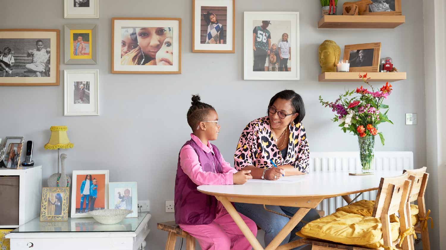A mother with her son doing homework at the dining table
