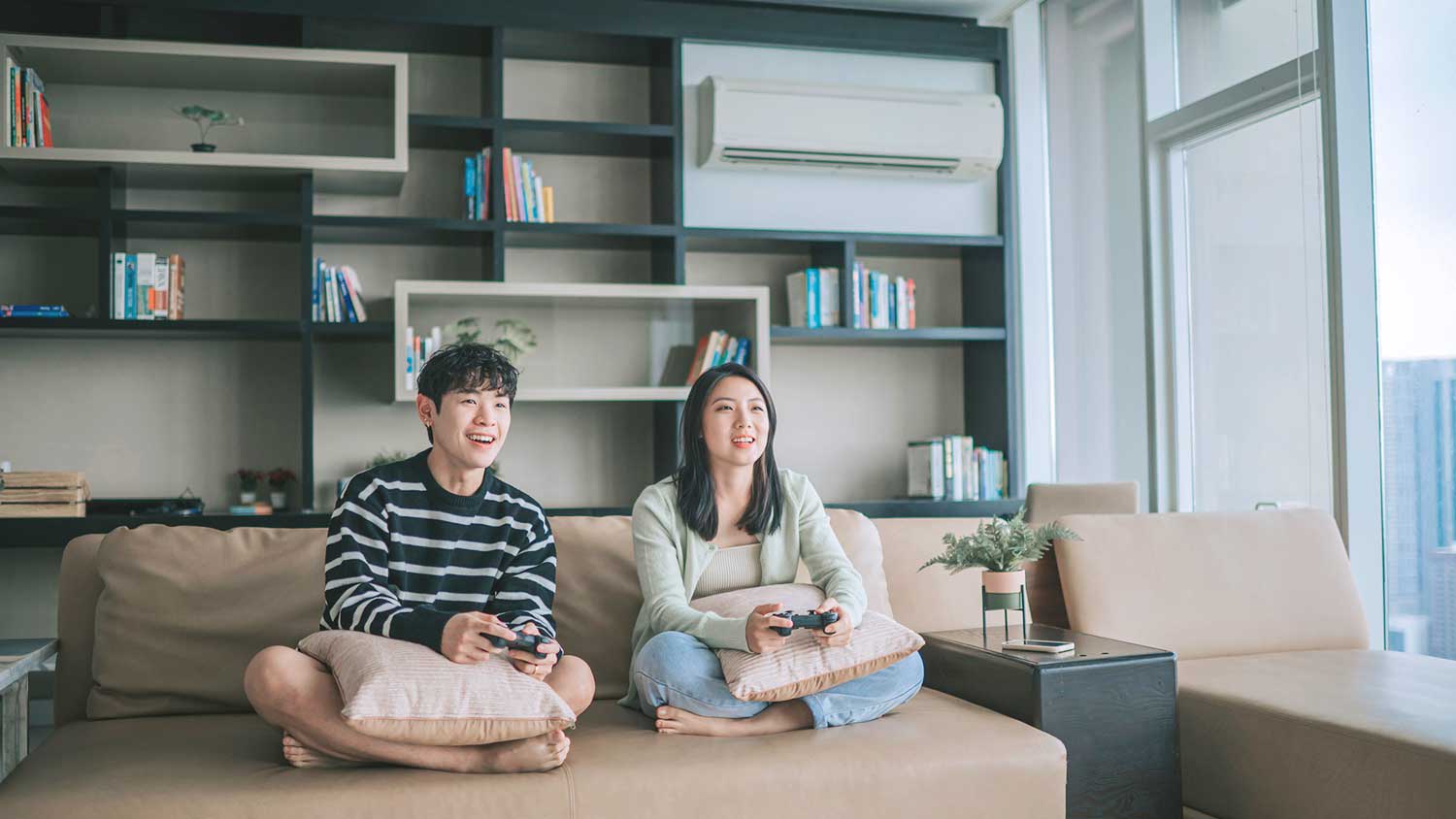 Siblings sitting on the couch playing video games