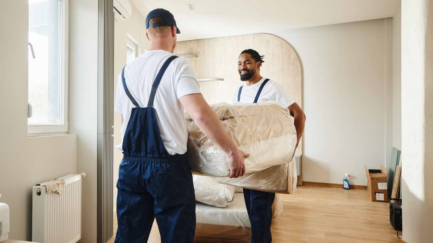 Movers carrying furniture in the apartment