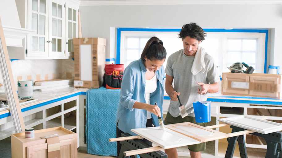 Couple painting kitchen cabinets