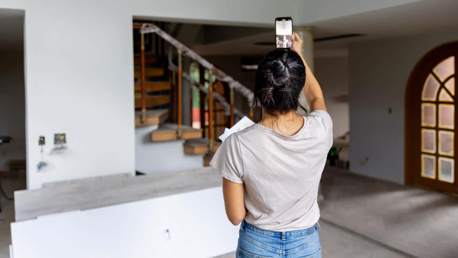 woman taking photos of home before renovation