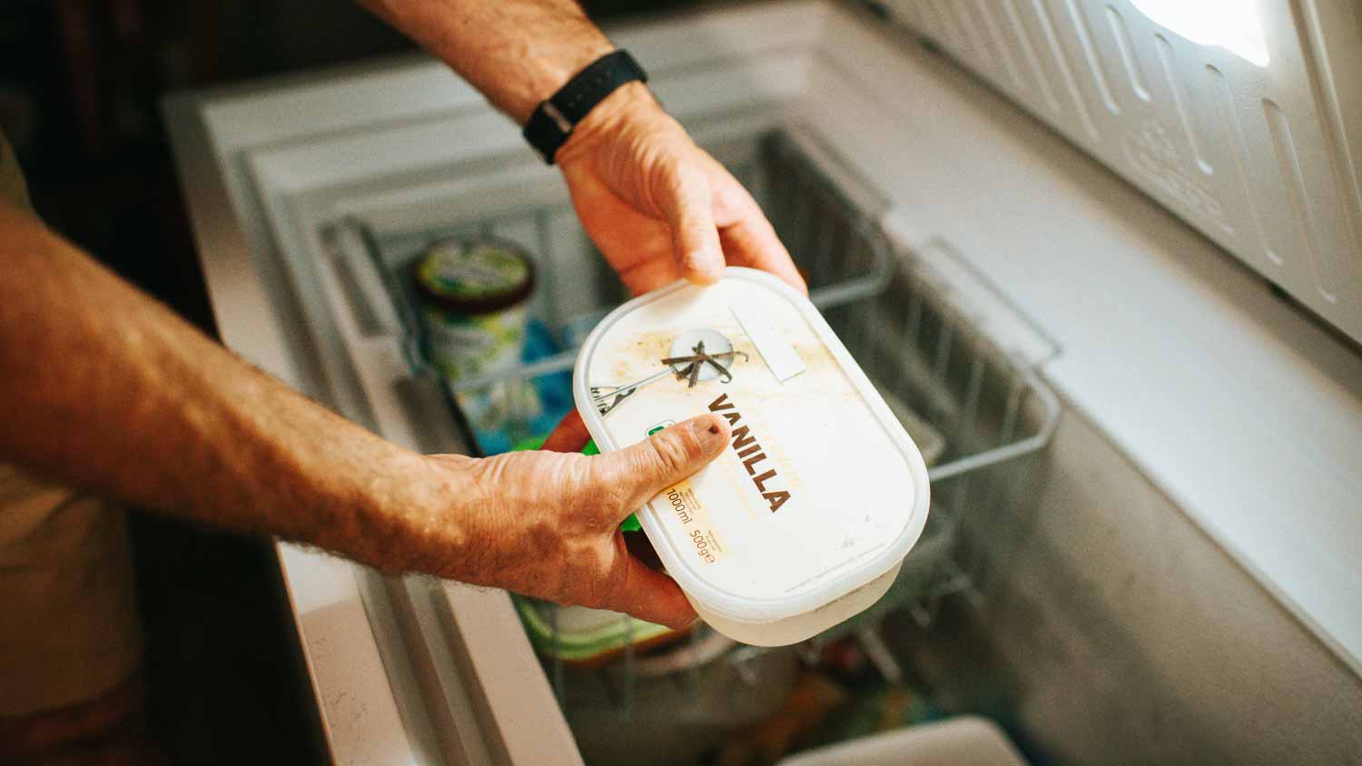 Man holding ice cream in the freezer