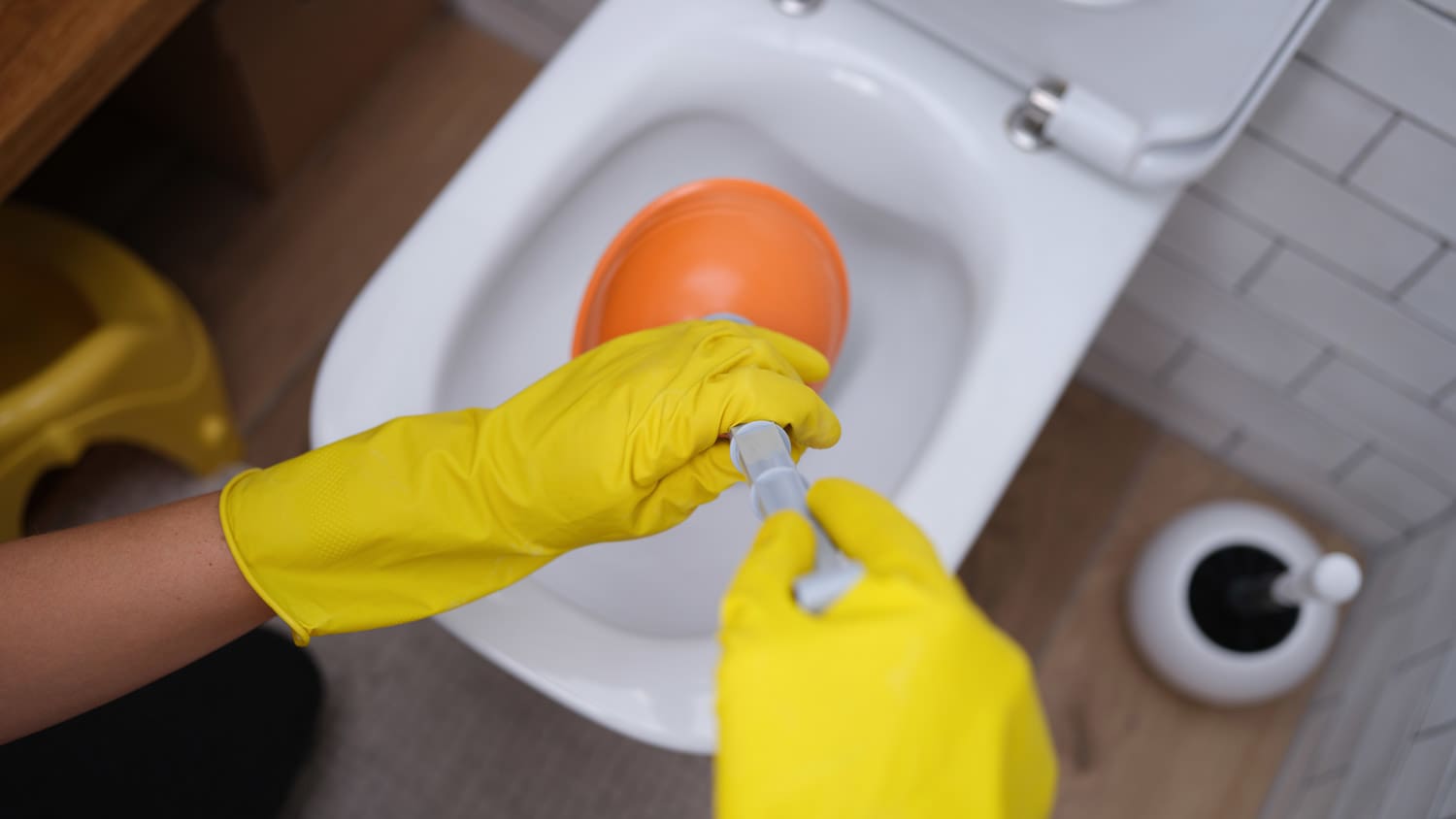 person using toilet plunger