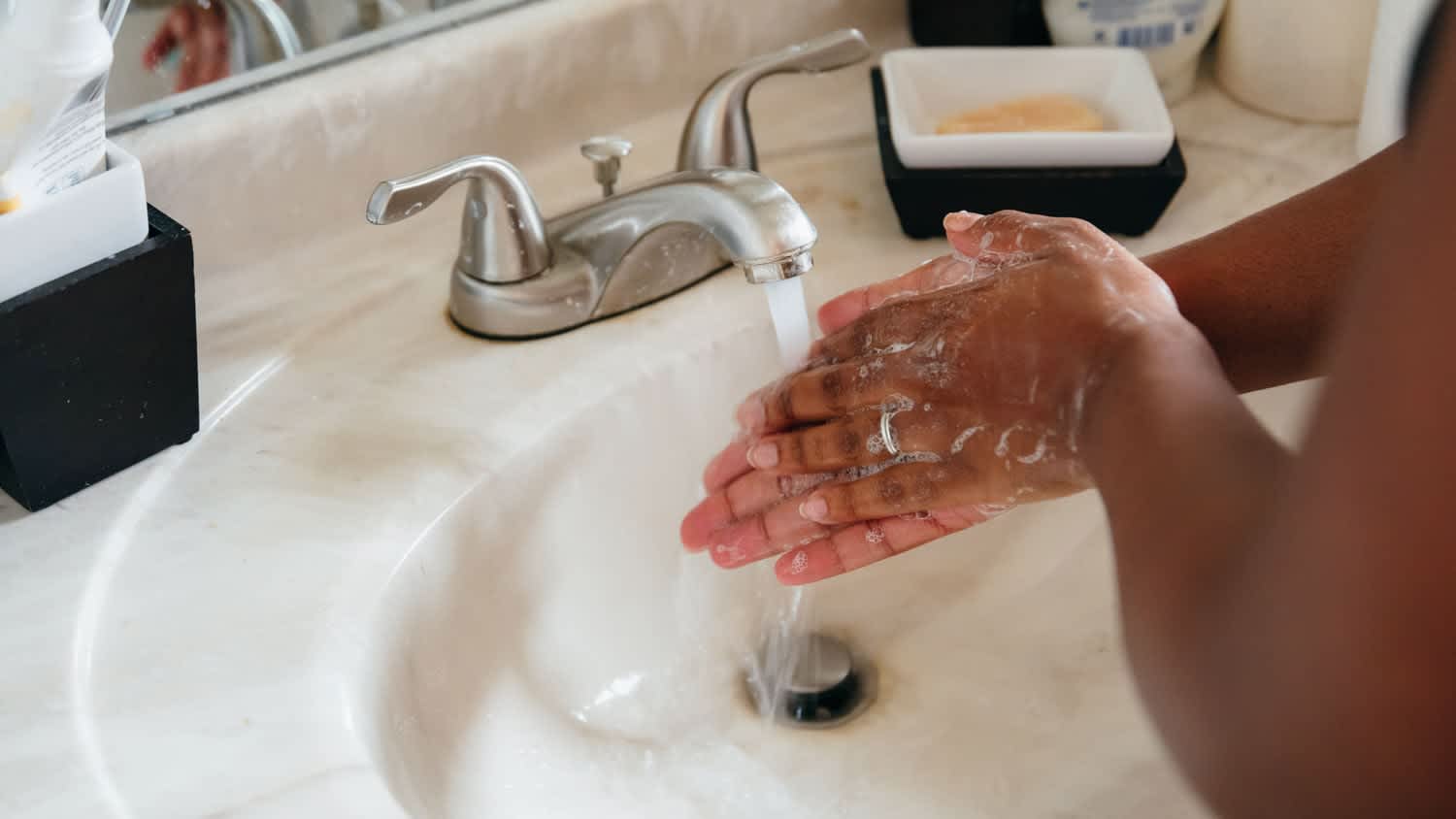 woman washing hands in kitchen sink