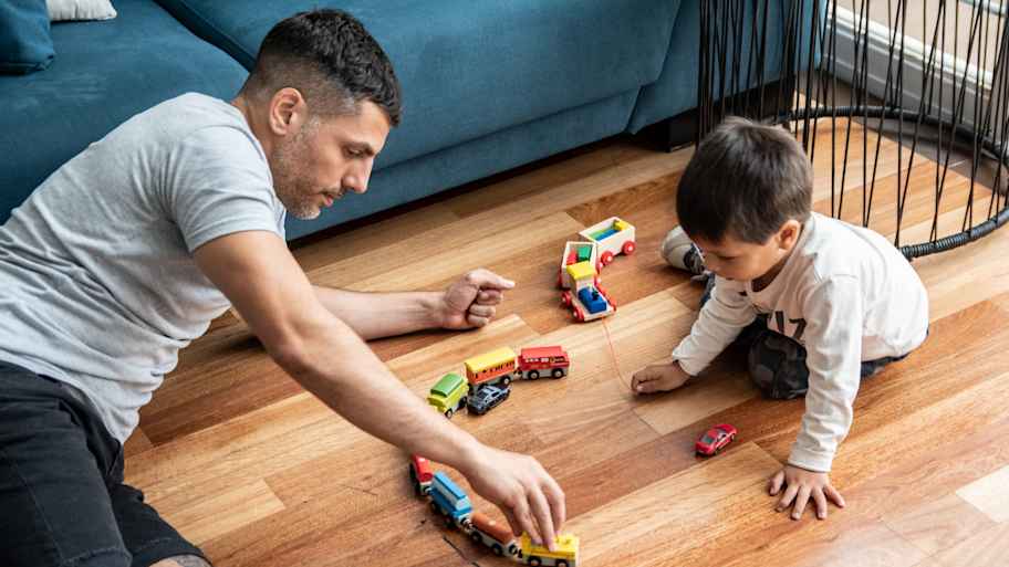 Father and son playing with toys on the floor