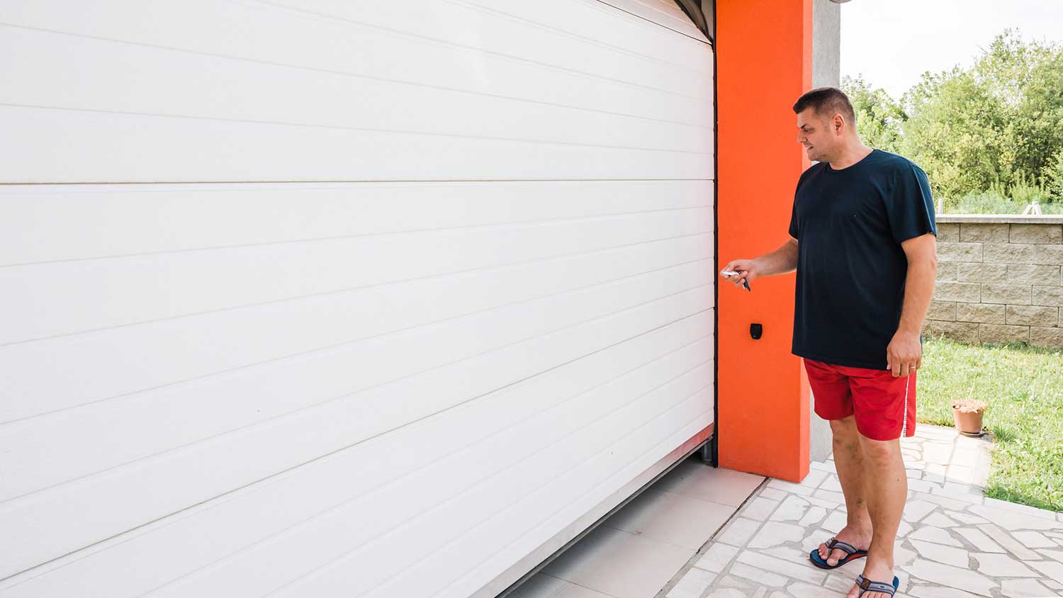 Man using remote control to open garage door