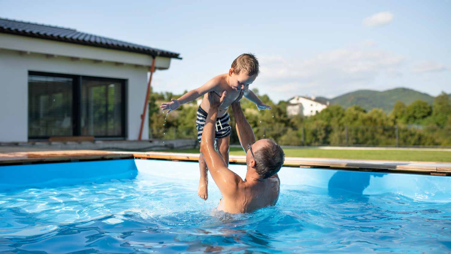 man playing with his son in the pool