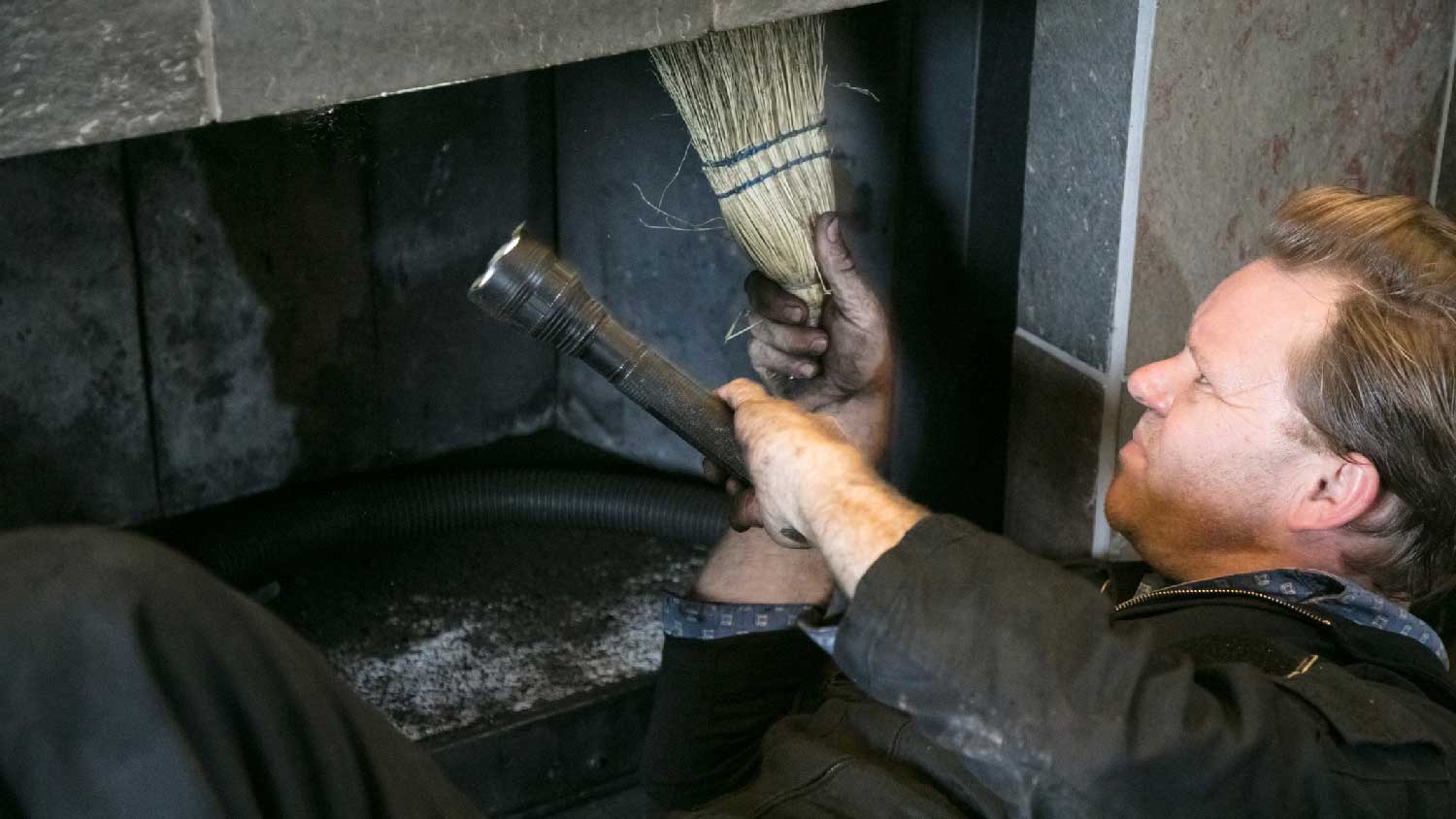 A man inspecting a fireplace