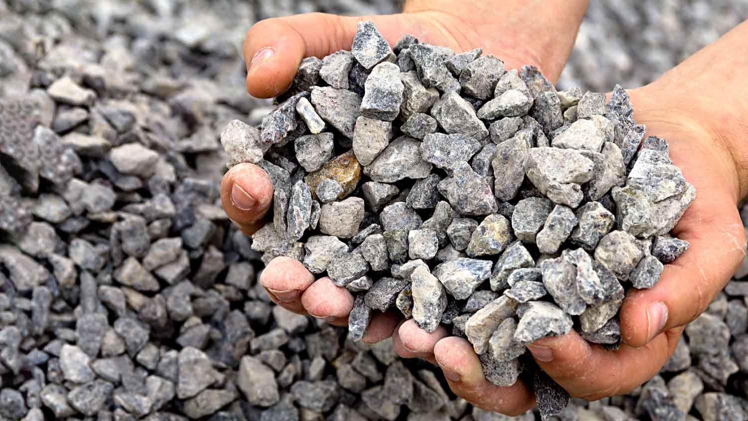 man holding gravel in hand