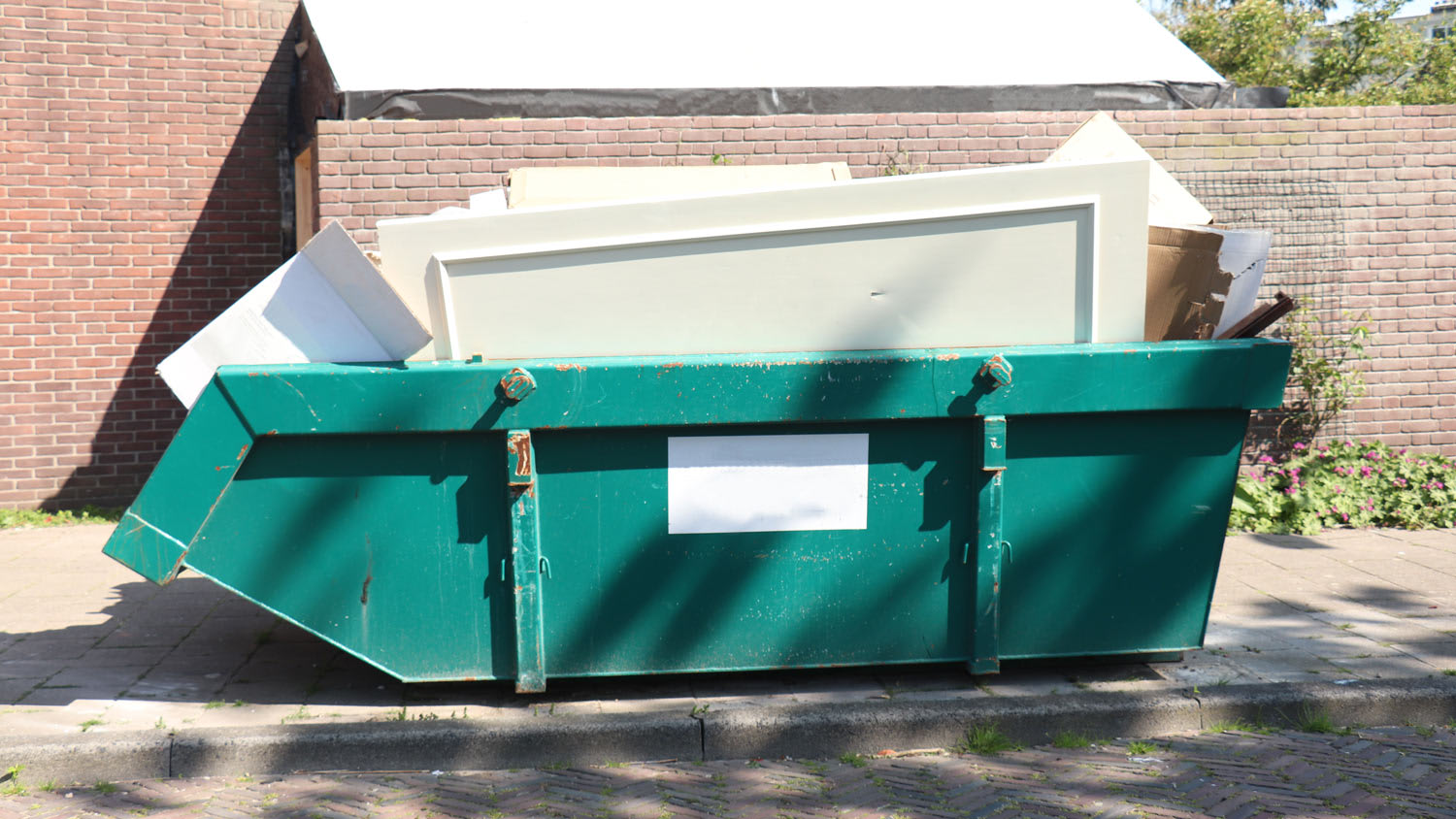 Loaded dumpster near a home renovation
