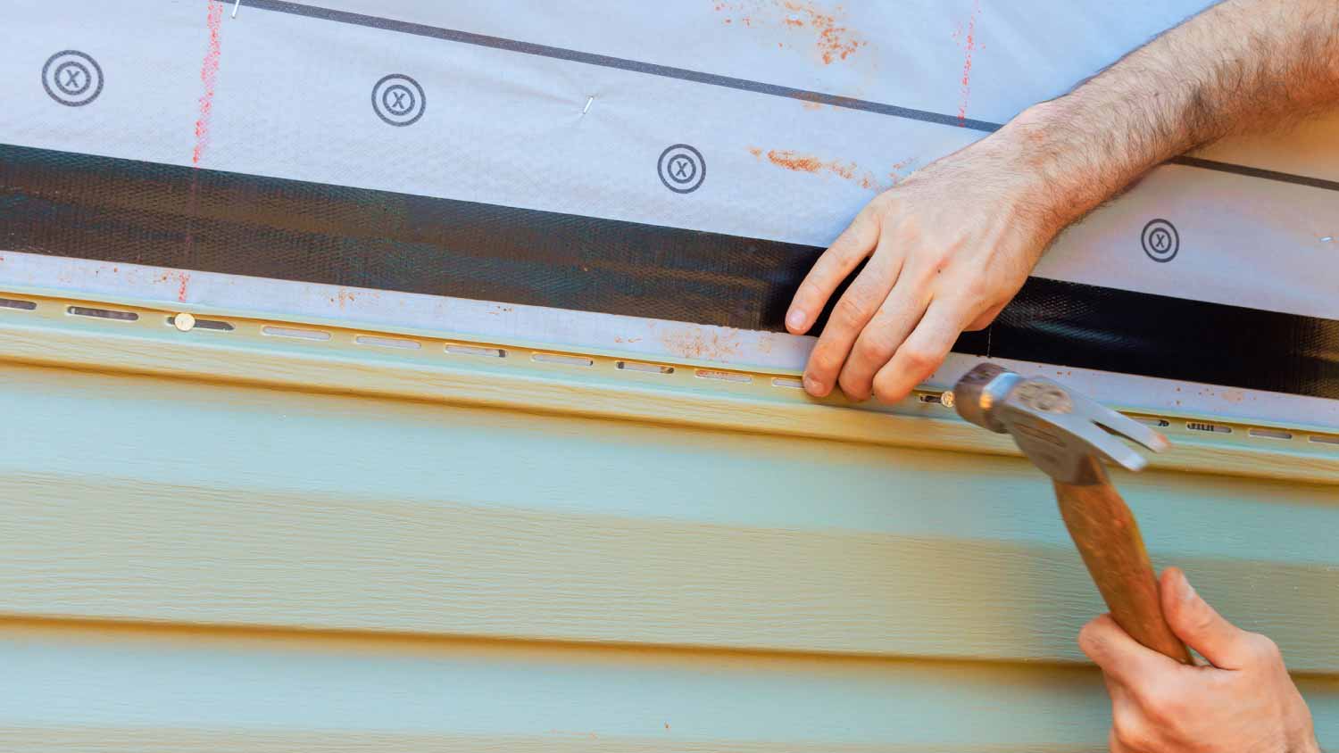Worker installing new siding