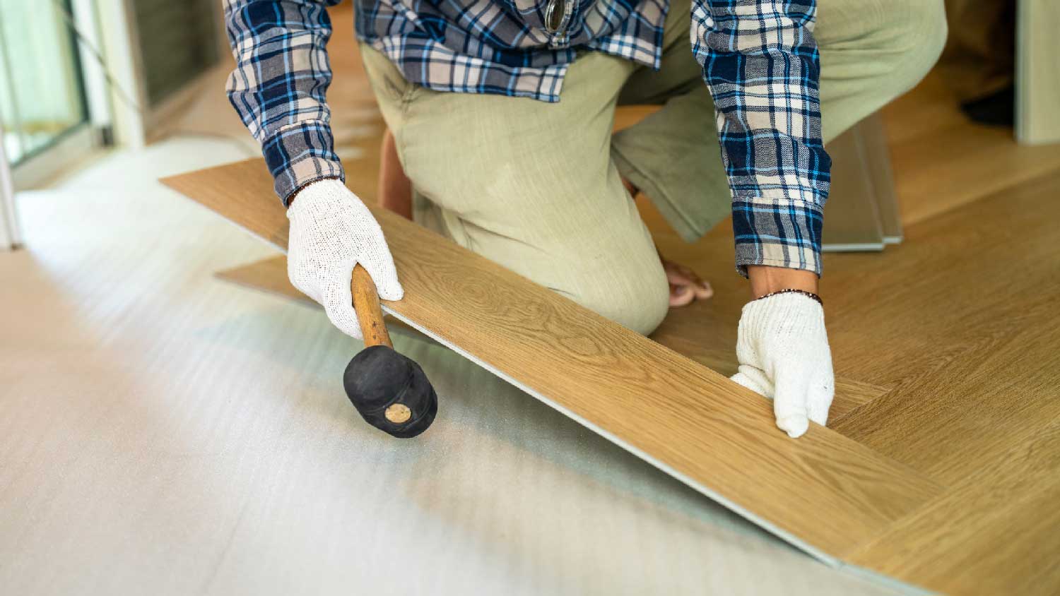 A man installs laminate flooring