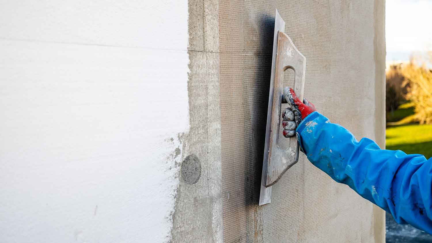 Contractor repairing EIFS stucco wall