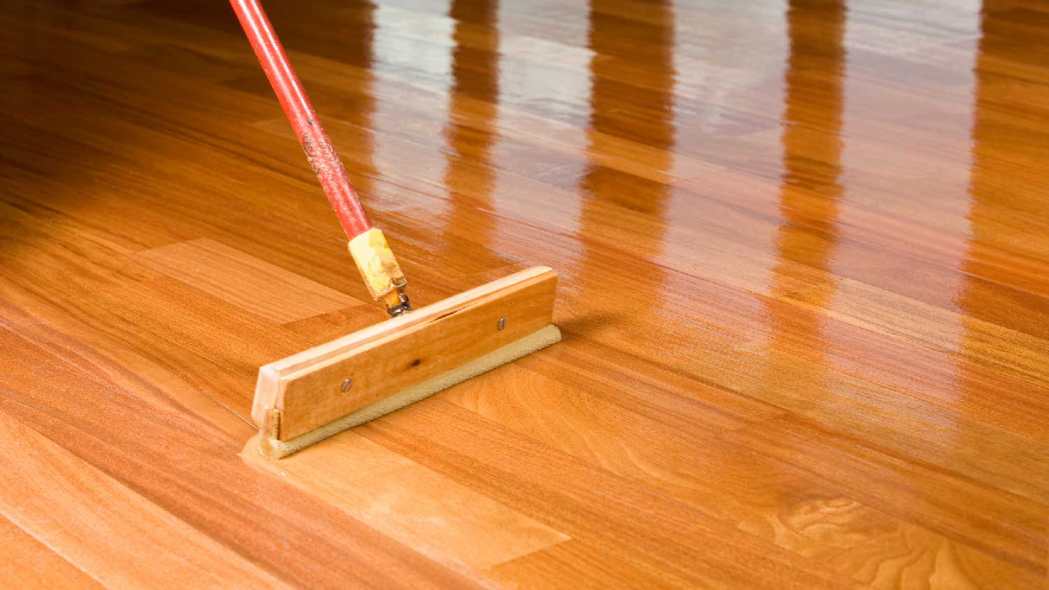 Close-up of a squeegee refinishing hardwood floors