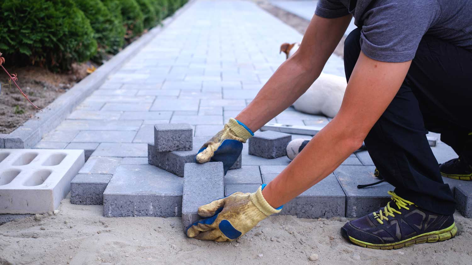 man laying down paving stones