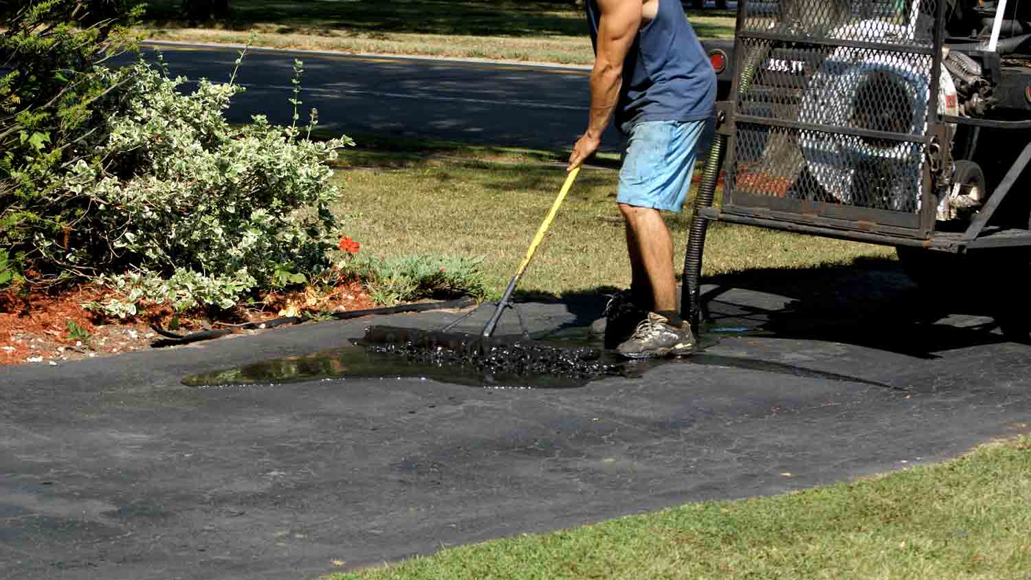 applying sealant to asphalt driveway