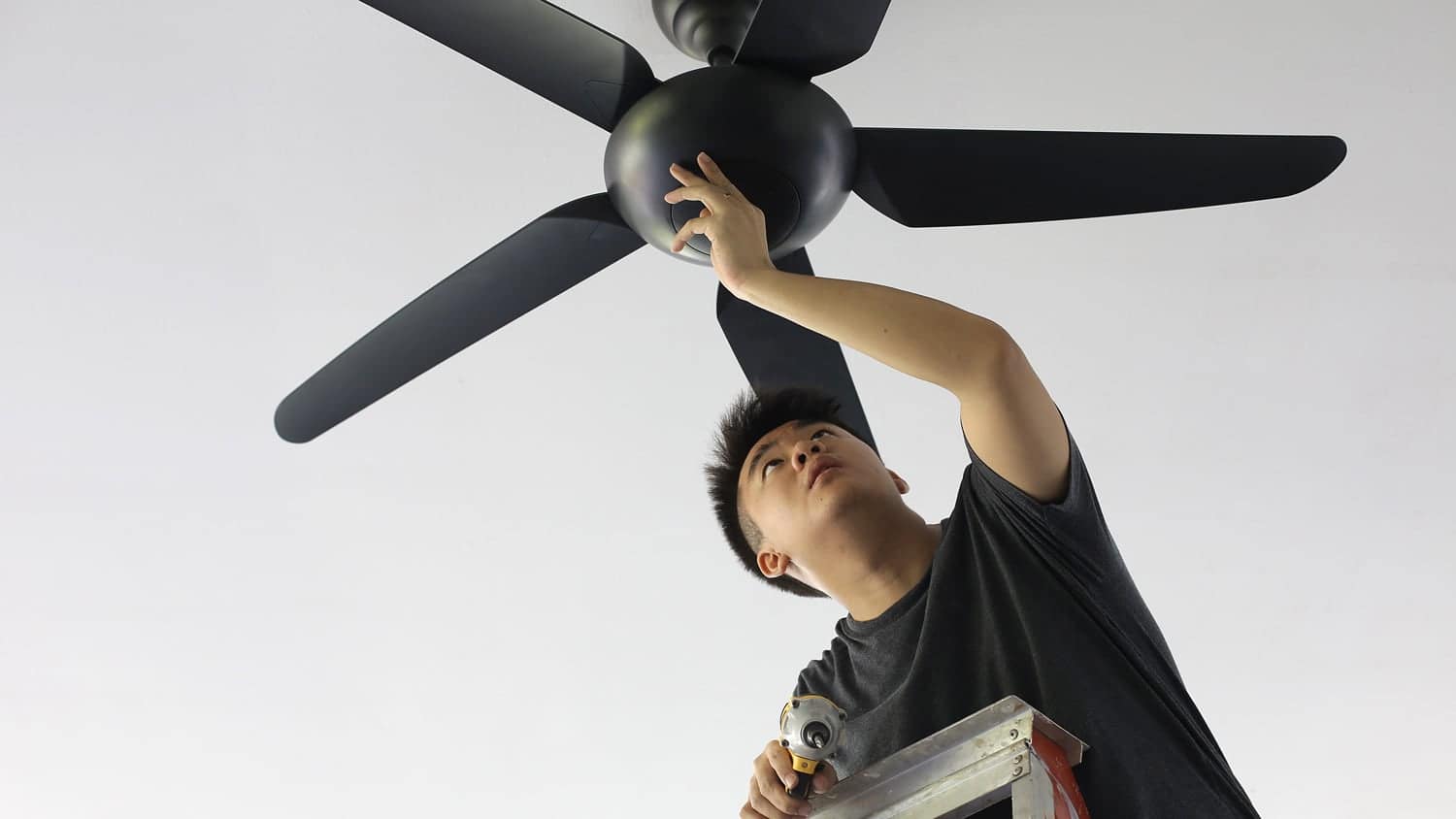 Man repairing ceiling fan