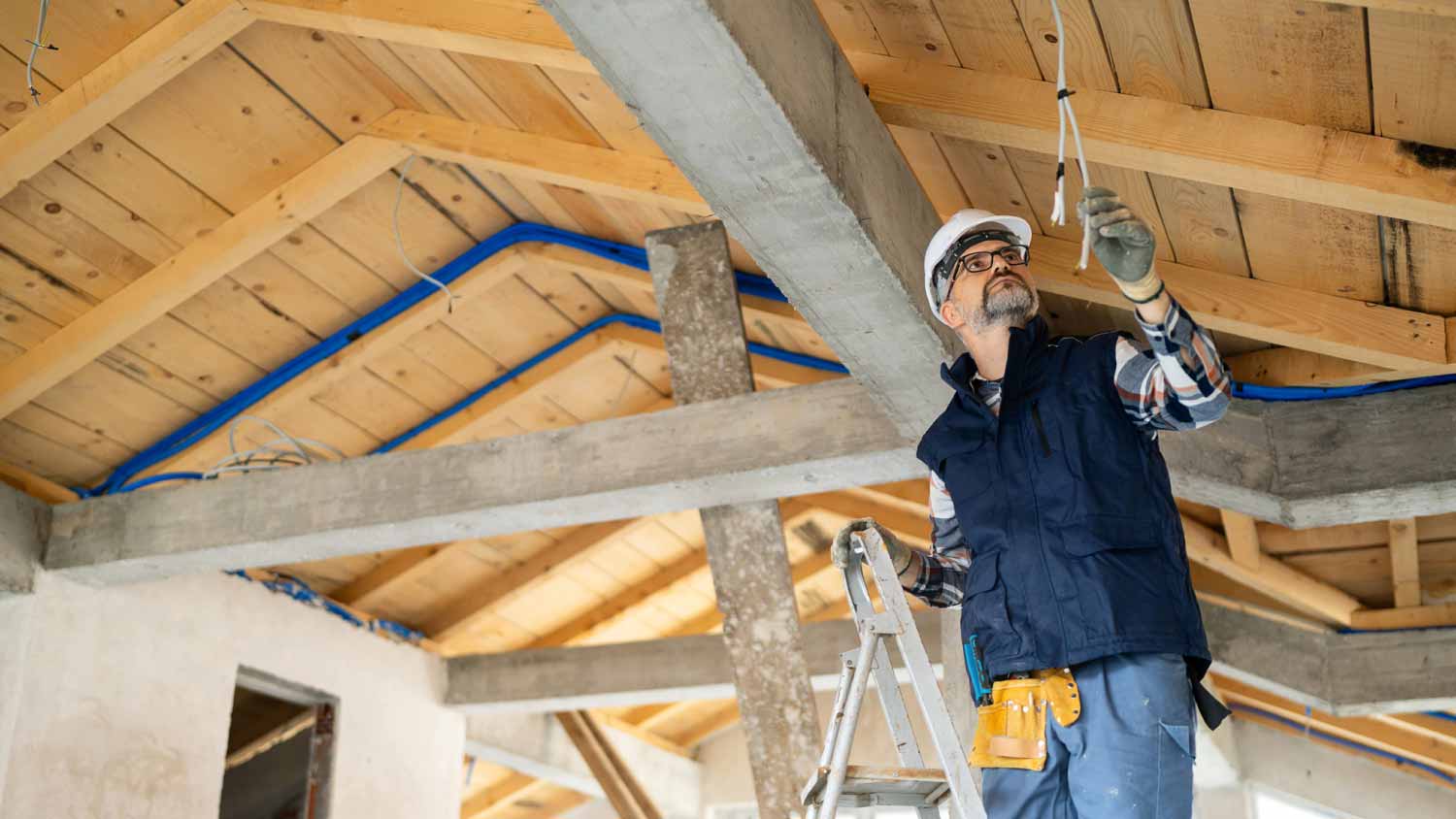 Electrician inspecting wiring on a ceiling
