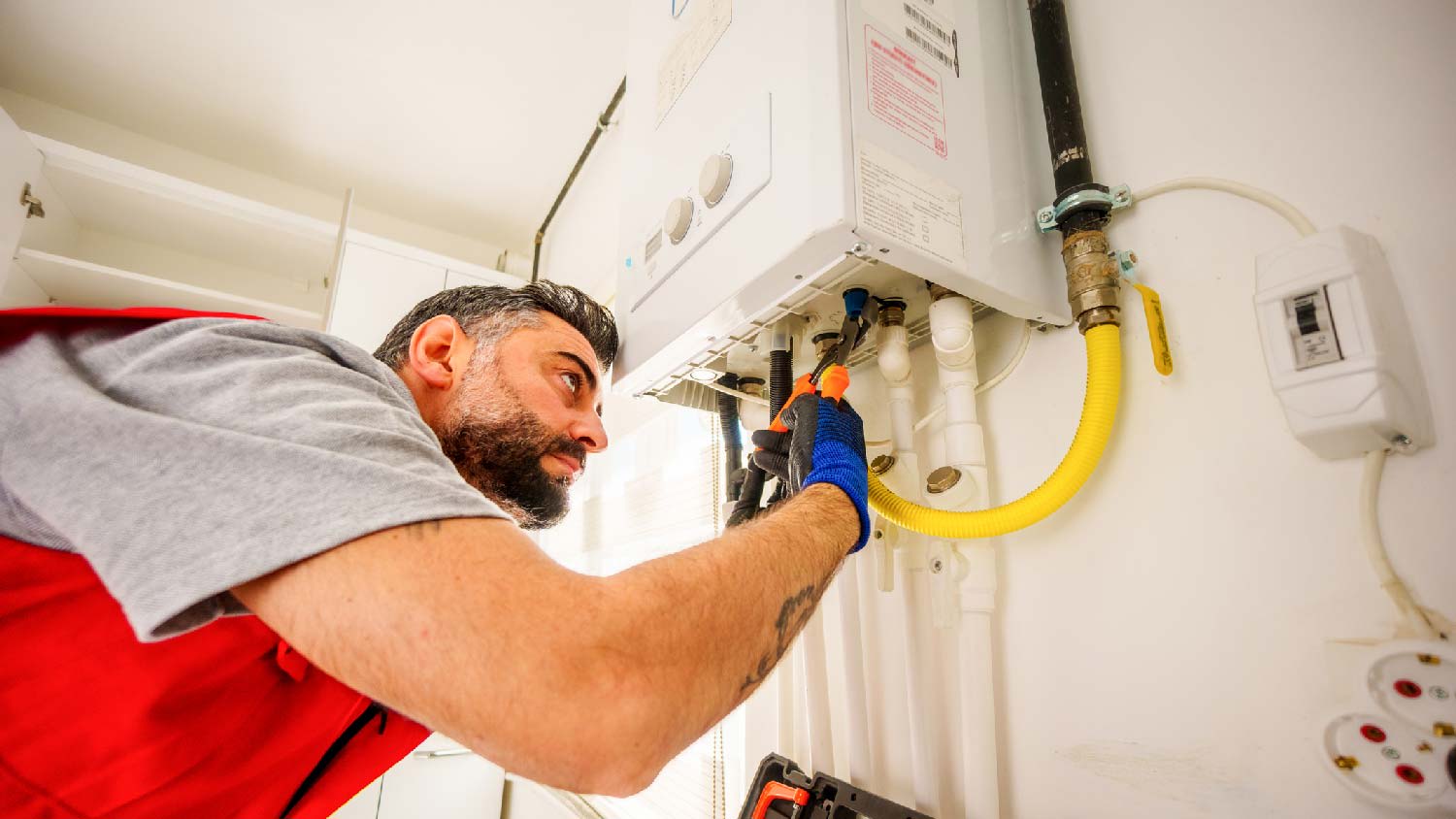 A professional repairing a gas water heater