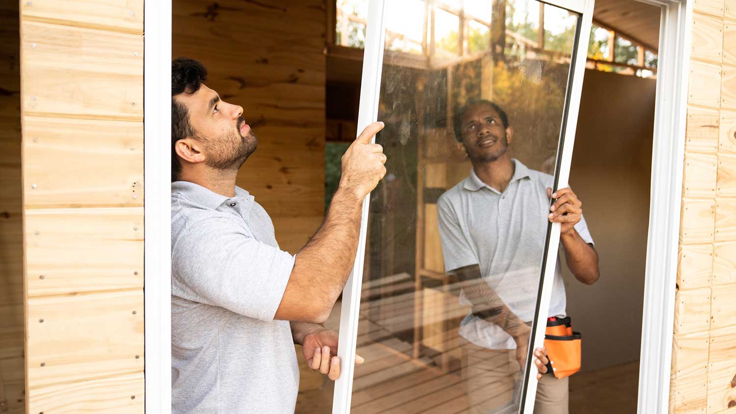 Professionals installing an impact window
