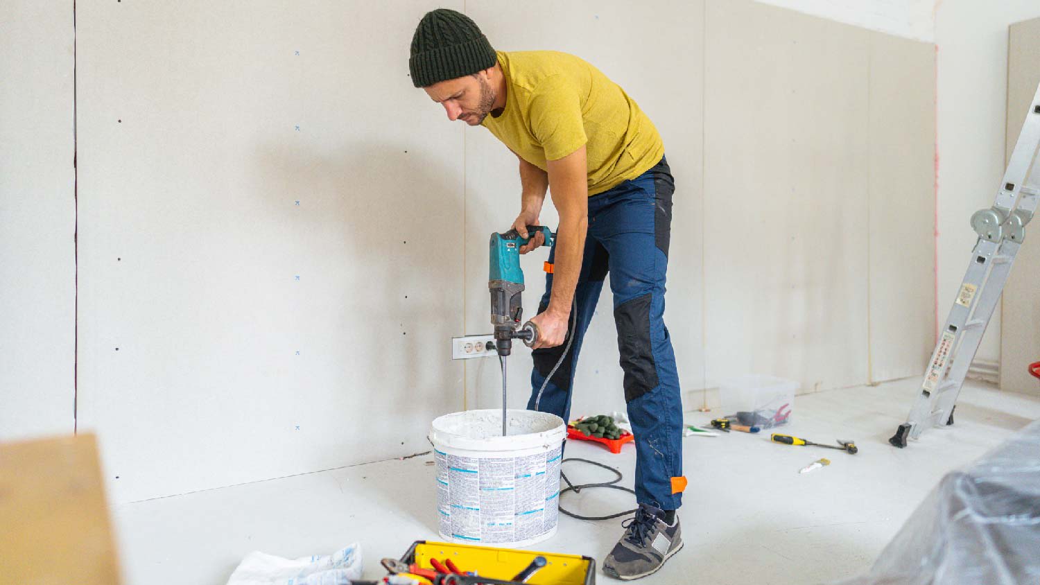 A professional mixing drywall mud