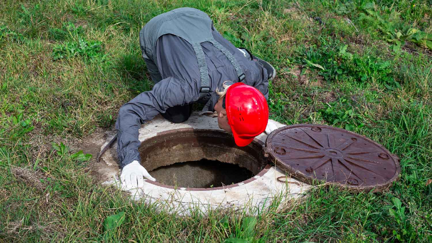 A professional inspecting a septic tank