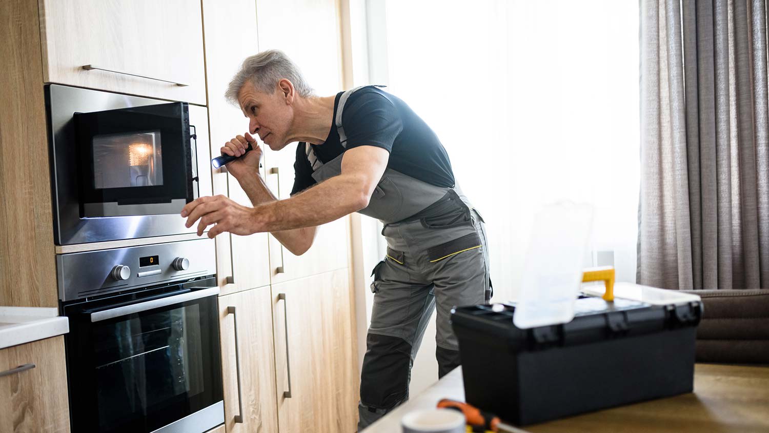 A man inspecting a microwave