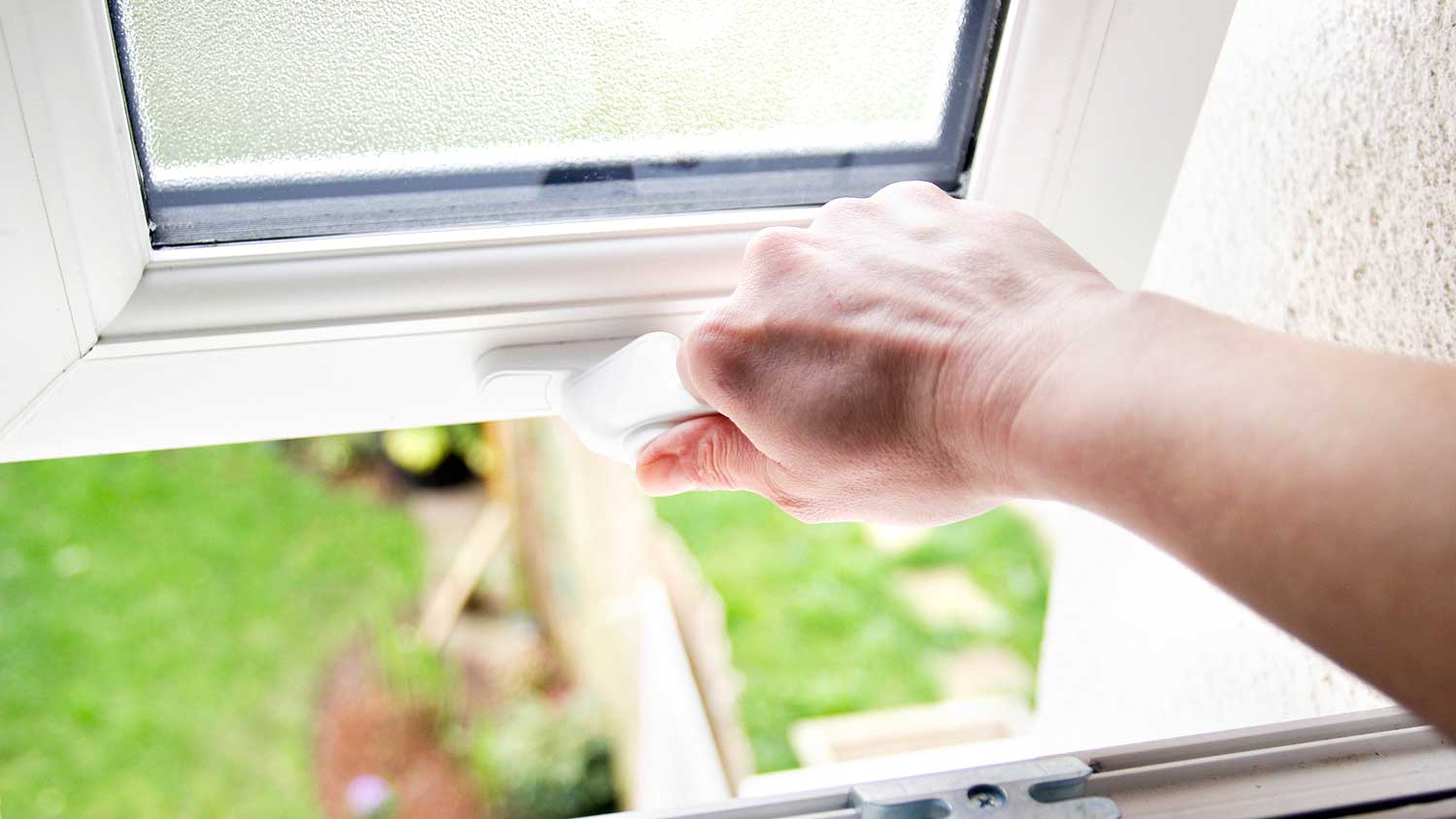 A person opening a window.