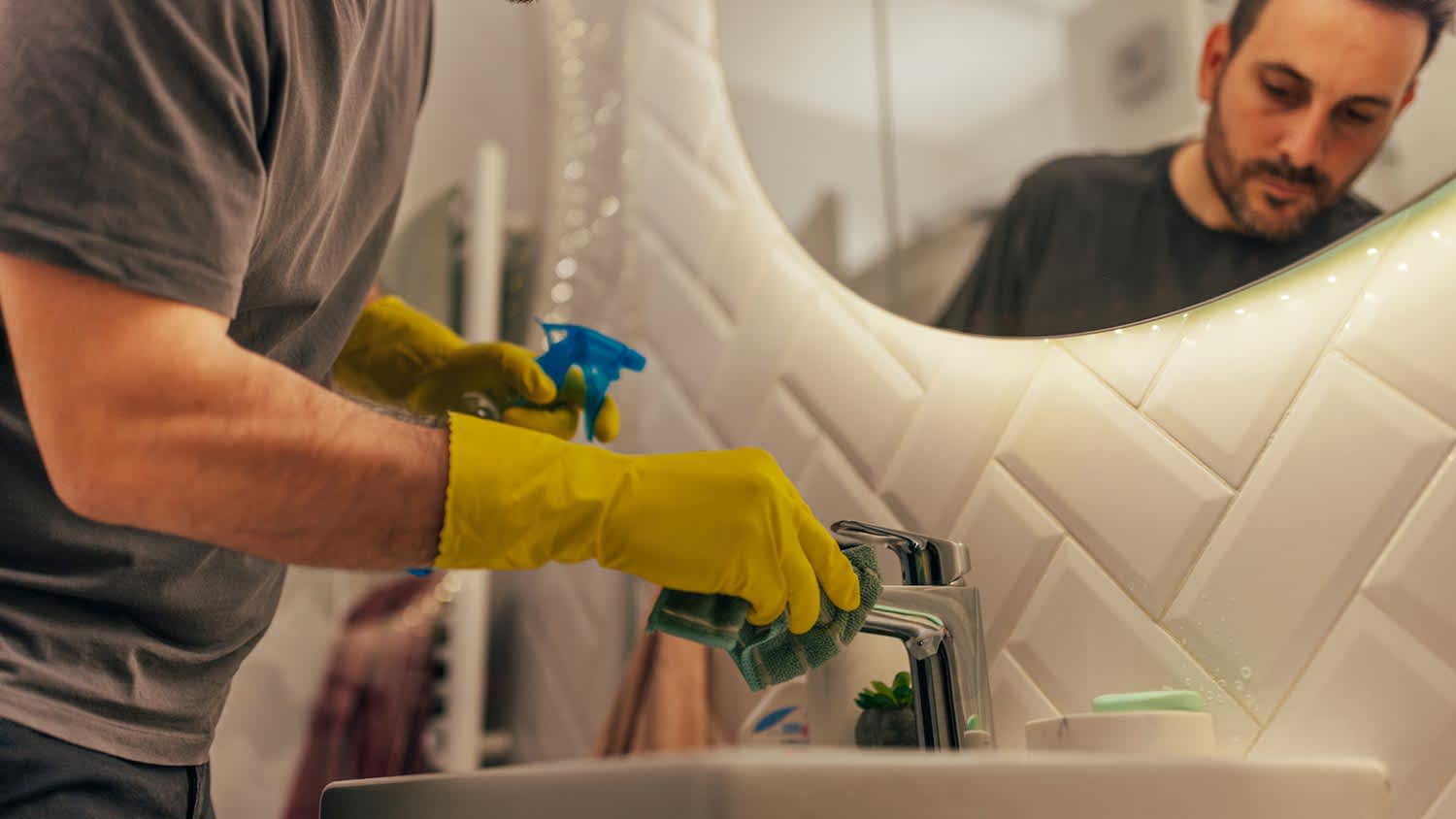 A man cleaning thoroughly a bathroom