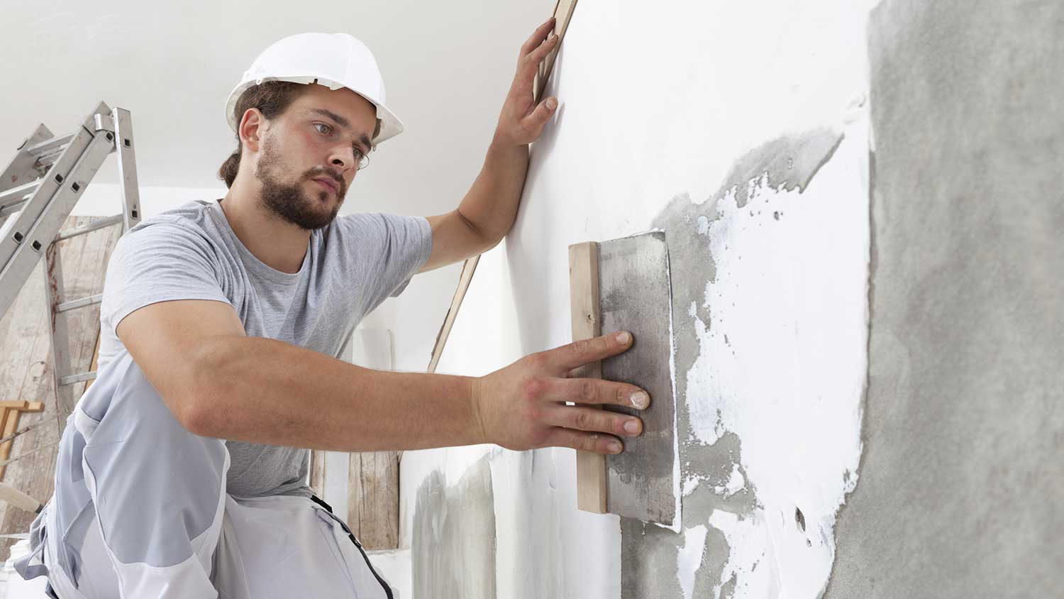 Worker plastering the wall of a new house