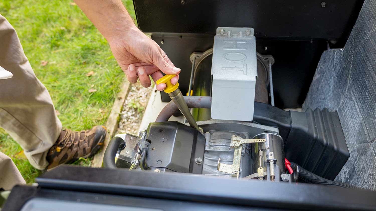man checking engine oil on generator