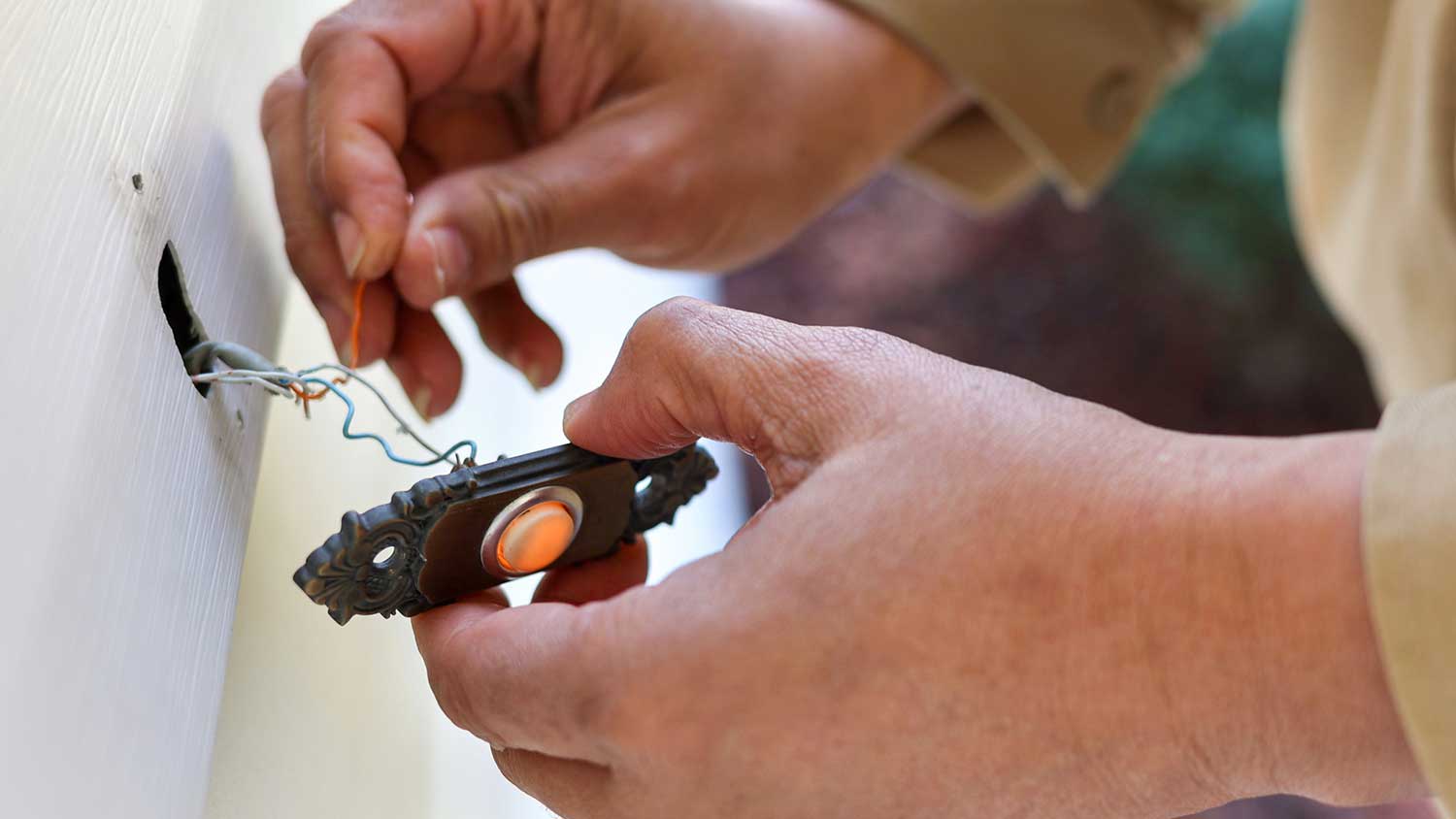 A person wiring a doorbell