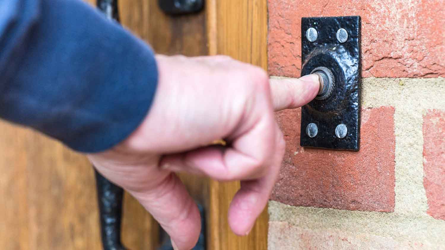A person ringing a doorbell