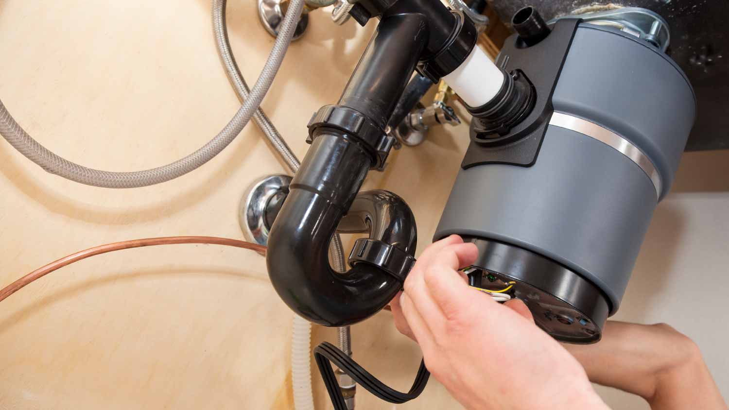 A worker installing a garbage disposal