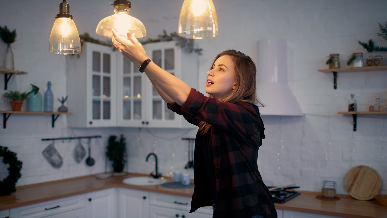 A woman changing a light bulb at her home