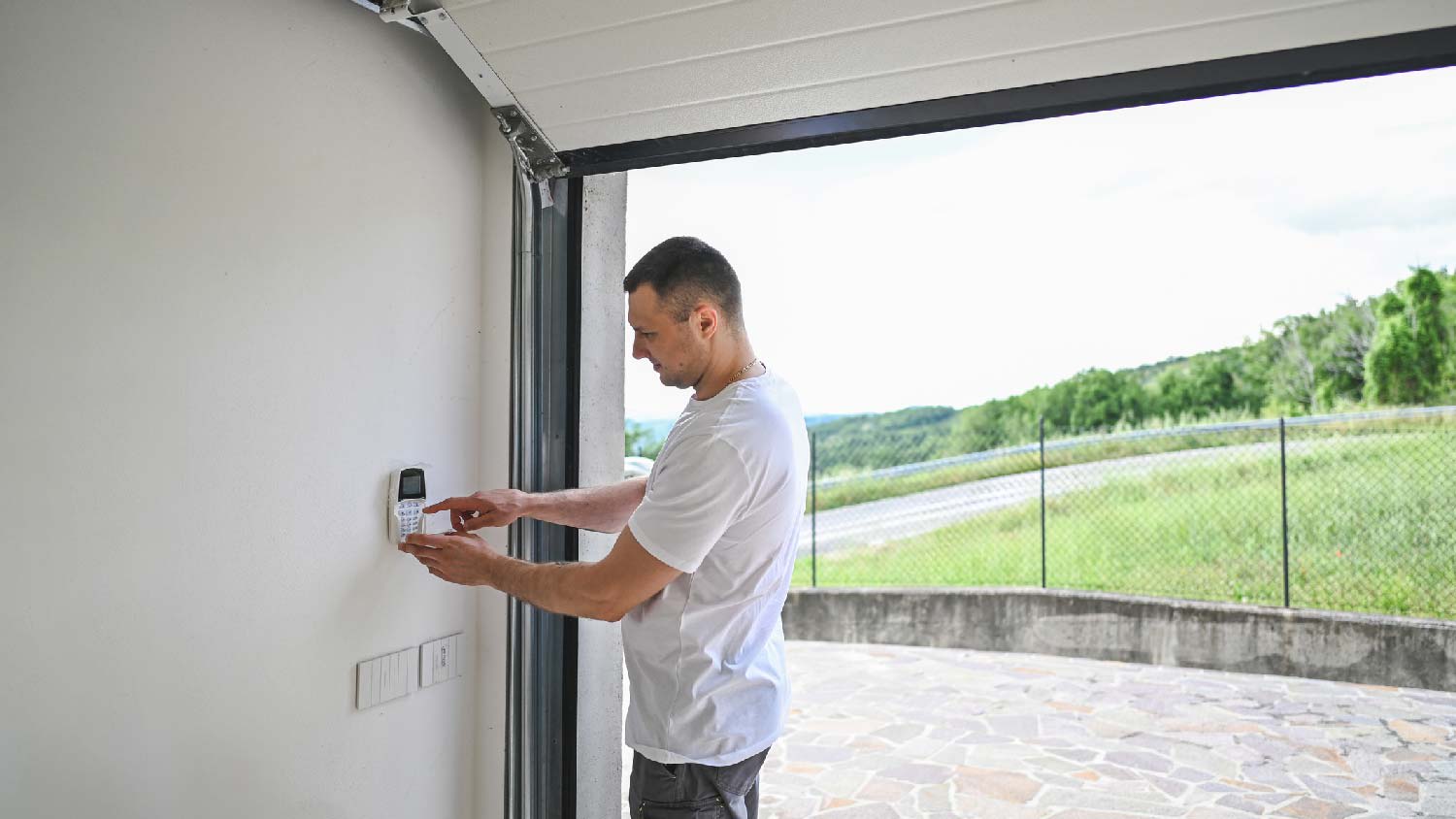 A man lubricating the garage door mechanism