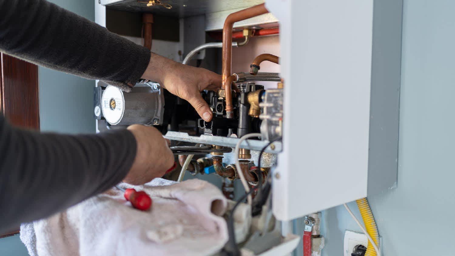 A person inspecting a gas heater