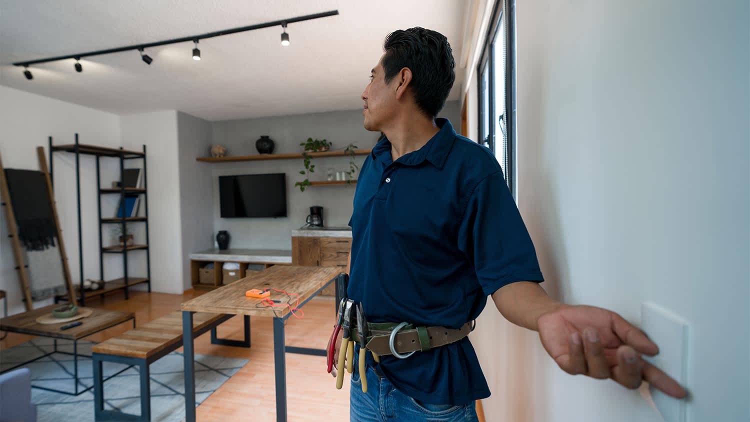 An electrician repairing a light switch