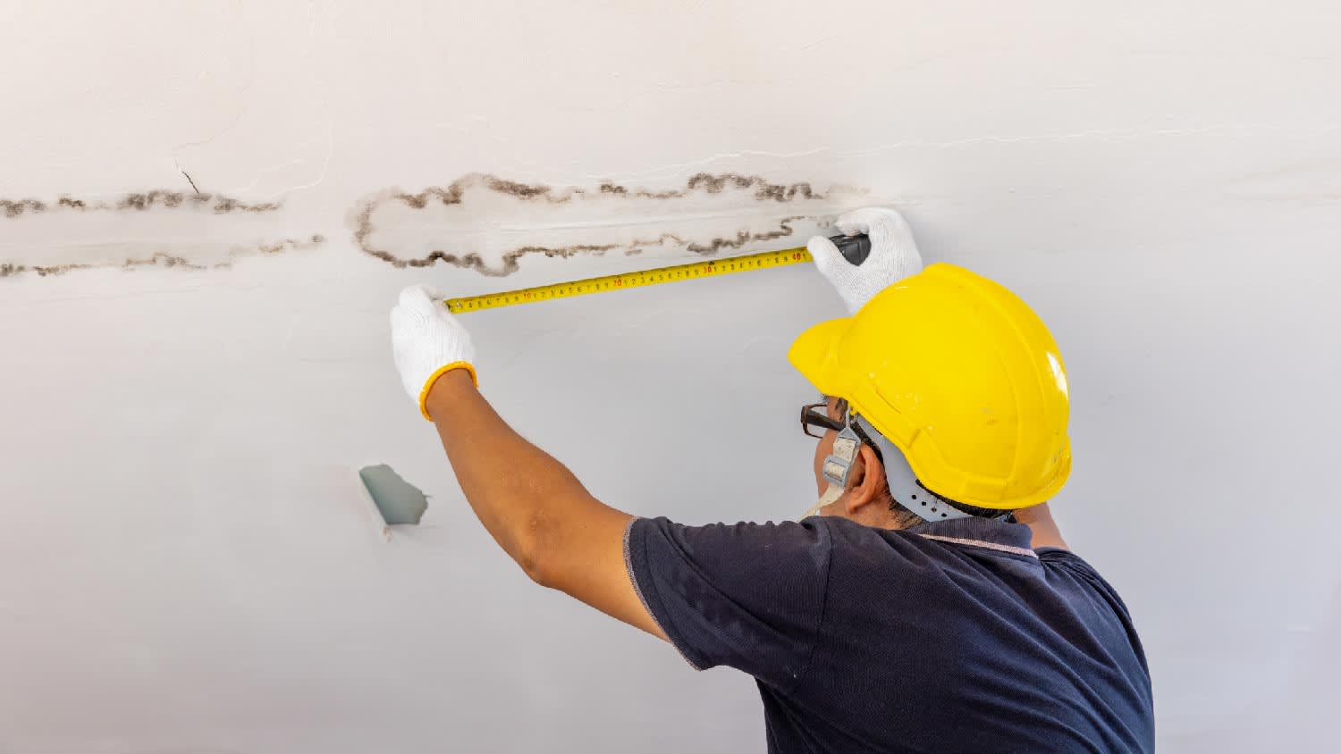 A professional inspecting water damage on the ceiling