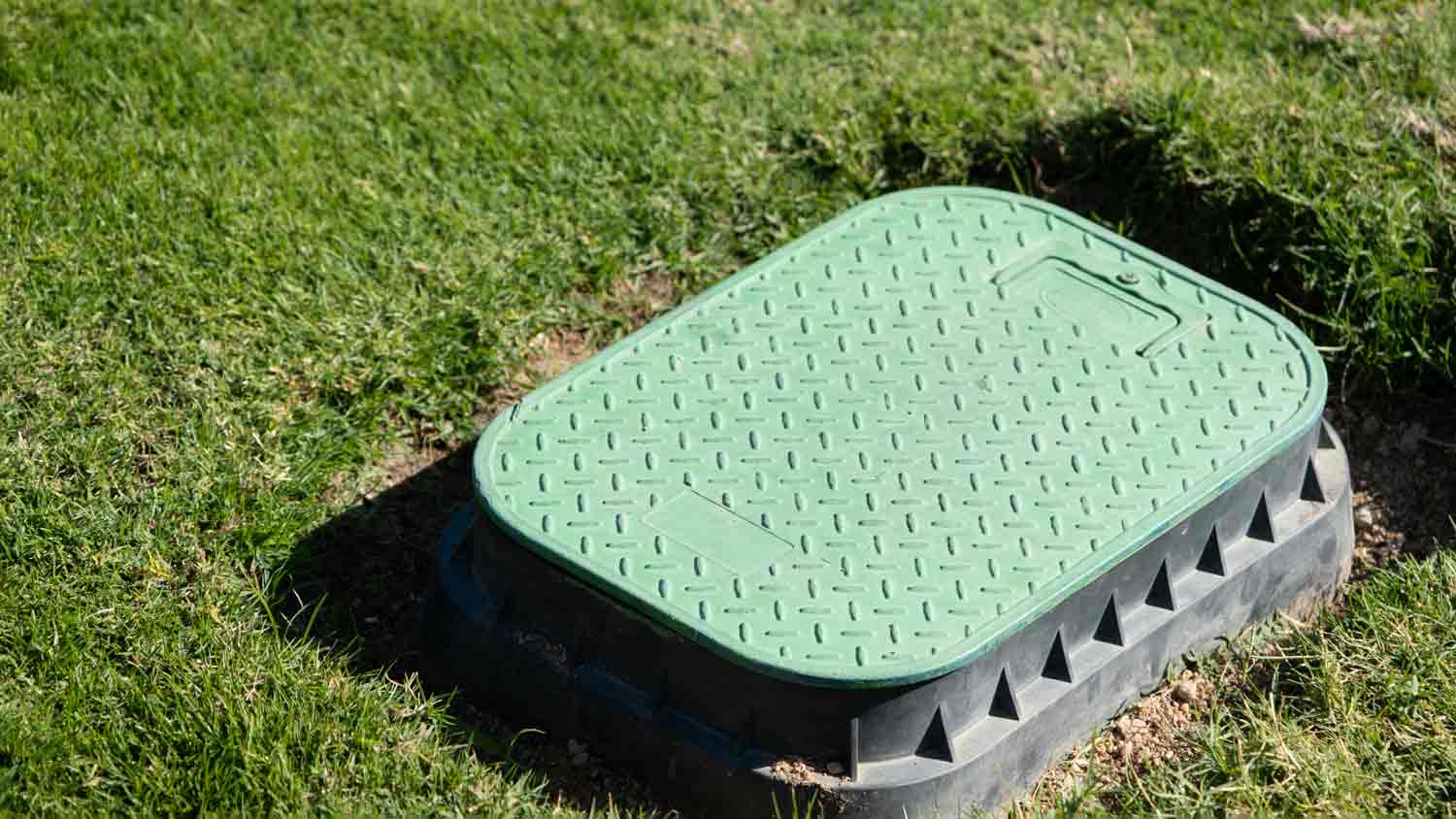 green valve box in yard