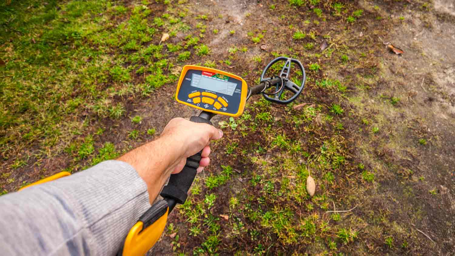 man in yard with metal detector